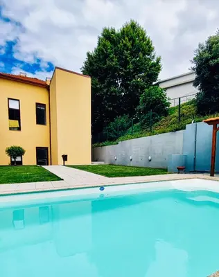 a swimming pool in front of a house at Cozy Loft w Poll Near Porto Cellars in Vila Nova de Gaia