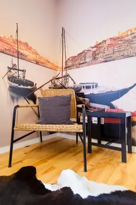 a bench in a room with two boats on the wall at Cozy Loft w Poll Near Porto Cellars in Vila Nova de Gaia