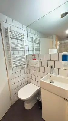 a bathroom with a toilet and a sink and a mirror at Classic Freitas in Porto
