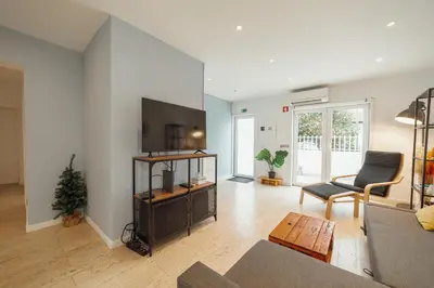a living room with a couch and a table at Porto Window House by Vacationy in Bandeira