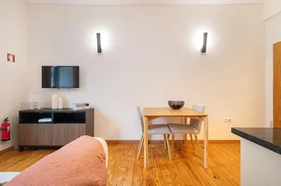a living room with a table and a small table and chair at The Cozy Loft in Porto