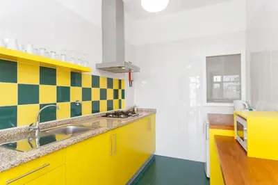 a kitchen with yellow cabinets and a sink at Egg Nuts Apartment in Porto