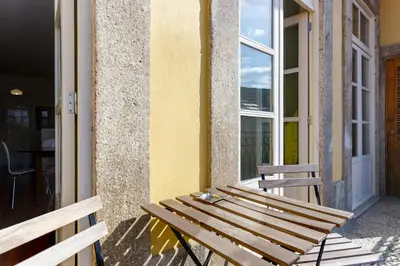 a wooden bench sitting on the side of a building at Egg Nuts Apartment in Porto