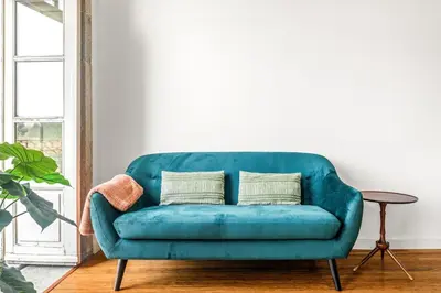 a blue couch in a living room with a table at Egg Nuts Apartment in Porto