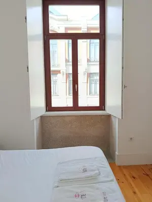 a bed in a room with a window at Quiet, bright apt near Bolhão in Porto