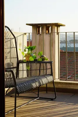 a bench sitting on a balcony with plants on it at Sol Do Porto - 2 bed Penthouse Luis Bridge view in Porto