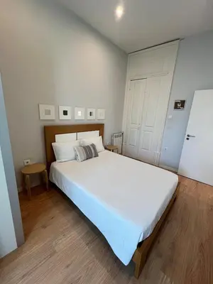 a bedroom with a large white bed and a white door at Studio in a typical Porto house in Porto