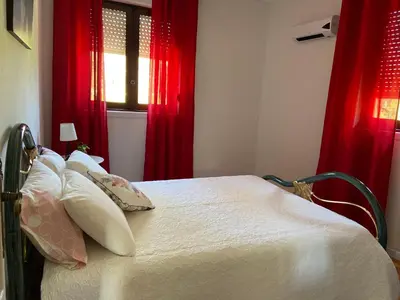 a bedroom with a bed with red curtains at House T3 in Vila Nova de Gaia