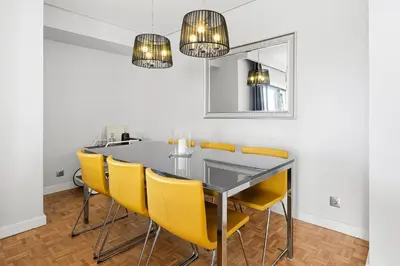 a dining room with a glass table and yellow chairs at GuestReady - Cosy Porto retreat in Porto
