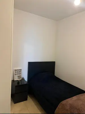 a bedroom with a black bed and a night stand at Quarto no centro do Porto in Porto