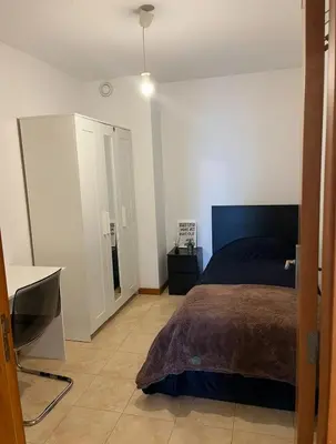 a bedroom with a bed and a desk in it at Quarto no centro do Porto in Porto