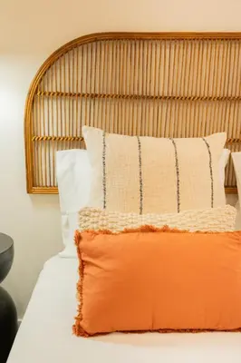 a bed with an orange and white pillow on it at Douro Prestige Studio in Vila Nova de Gaia