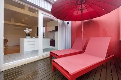 a red bench with an umbrella in a kitchen at Magnolia 6 Luxury with AC Metro Downtown Porto in Porto