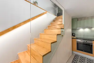 a staircase in a kitchen with white walls and wood at Victoria Project - Houses - Private Parking in Porto