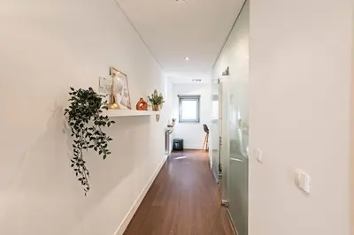 a hallway of a home with white walls and wooden floors at Carlos Alberto Apartment in Porto