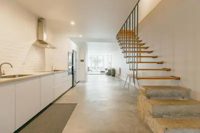 a kitchen with white cabinets and a staircase at Urban Refuge 4BD by Vacationy in Porto