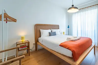 a bedroom with a large bed and a large window at Charming retreat near Boavista with elevator in Porto