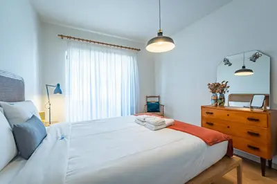 a bedroom with a bed and a dresser with a mirror at Charming retreat near Boavista with elevator in Porto