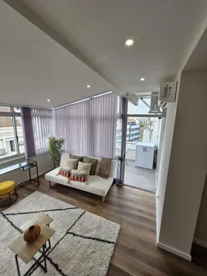 a living room with a white couch and a rug at Essence Santa Catarina Flat in Porto