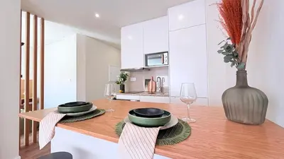 a kitchen with a wooden table with glasses and a vase at Essence Santa Catarina Flat in Porto