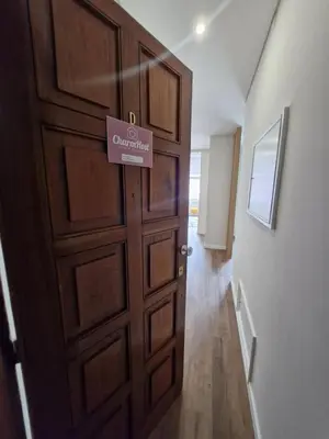 a wooden door with a sign on it next to a hallway at Essence Santa Catarina Flat in Porto