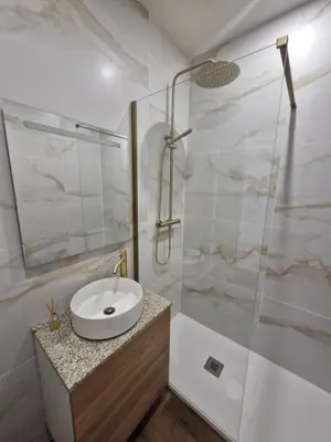 a bathroom with a sink and a glass shower at Essence Santa Catarina Flat in Porto
