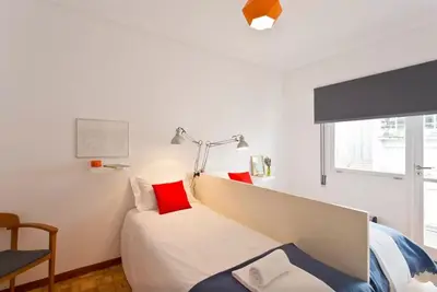 a white bedroom with a bed with red pillows at PinPorto City Center I in Porto