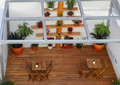 a room with tables and chairs and potted plants at Lusitana Hotel in Porto