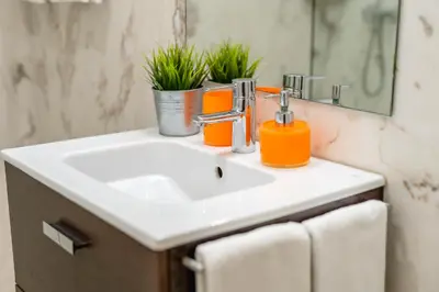 a bathroom sink with an orange soap dispenser on it at Merc Porto Clérigo's Place in Porto