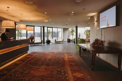 a lobby of a hotel with a man sitting at a bar at Timbre Heroismo in Porto