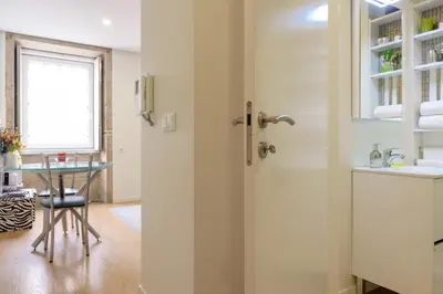 a kitchen with a door leading to a table at Cativo Flat in Porto