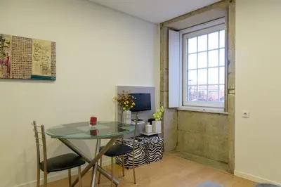 a dining room with a glass table and a window at Cativo Flat in Porto