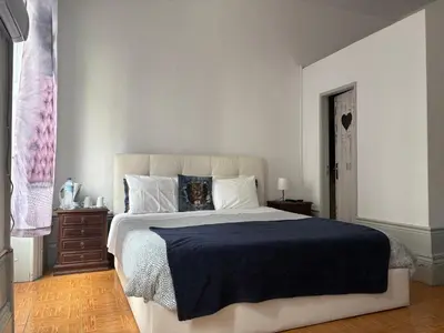a bedroom with a large bed with a blue blanket at Residência Céu Azul in Porto