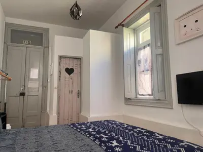 a bedroom with a bed and a window and a television at Residência Céu Azul in Porto