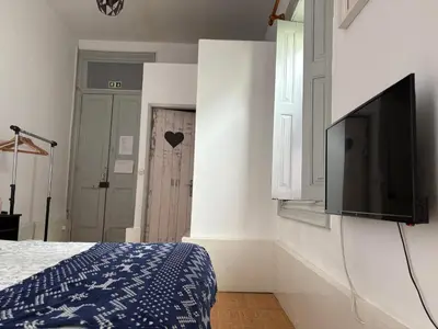 a bedroom with a bed and a flat screen tv at Residência Céu Azul in Porto
