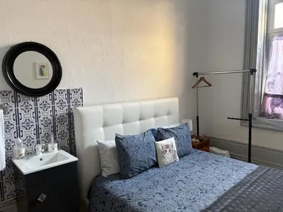a bedroom with a bed and a sink and a mirror at Residência Céu Azul in Porto