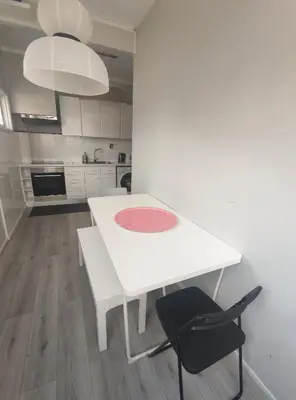 a white kitchen with a white table and black chairs at Baixa24 - Bolhão Apt with Sunset Rooftop in Porto