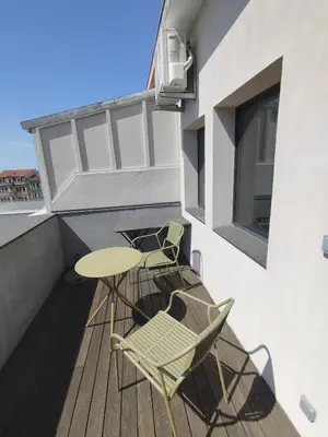 a patio with two chairs and a table on a balcony at Baixa24 - Bolhão Apt with Sunset Rooftop in Porto