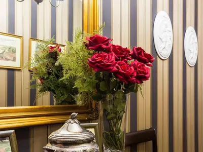 a vase filled with red roses on a table at Charming Antas House in Porto