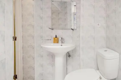 a white bathroom with a sink and a toilet at Ribeira Smart Flat in Porto