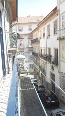a balcony of a building with cars parked on the street at Ribeira Smart Flat in Porto
