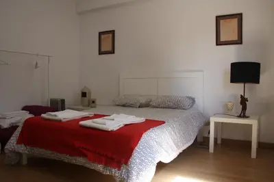 a bedroom with a bed with a red blanket at Alegria Rooms in Porto