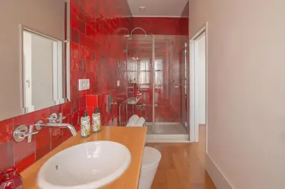 a red tiled bathroom with a sink and a shower at Fil's Place in Porto