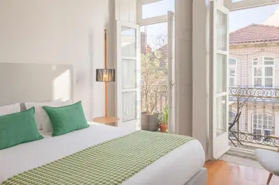 a white bedroom with a bed and a large window at Fil's Place in Porto