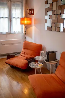 a living room with two orange chairs and a table at Fil's Place in Porto