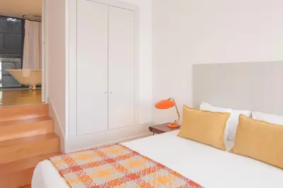 a white bedroom with a bed and a window at Fil's Place in Porto