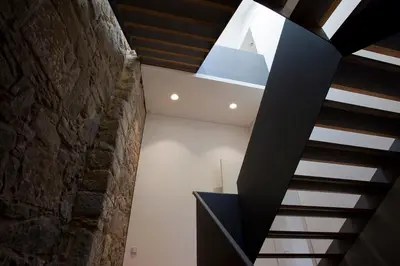 a skylight in a room with a stone wall at Belomont52 Guest House in Porto