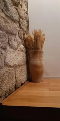 a vase sitting on a table next to a brick wall at Belomont52 Guest House in Porto