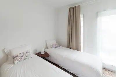 two white beds in a room with a window at CdC Apartments by Casa do Conto in Porto