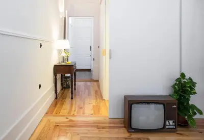 an old tv sitting on a wooden floor in a hallway at Studio 77 in Porto